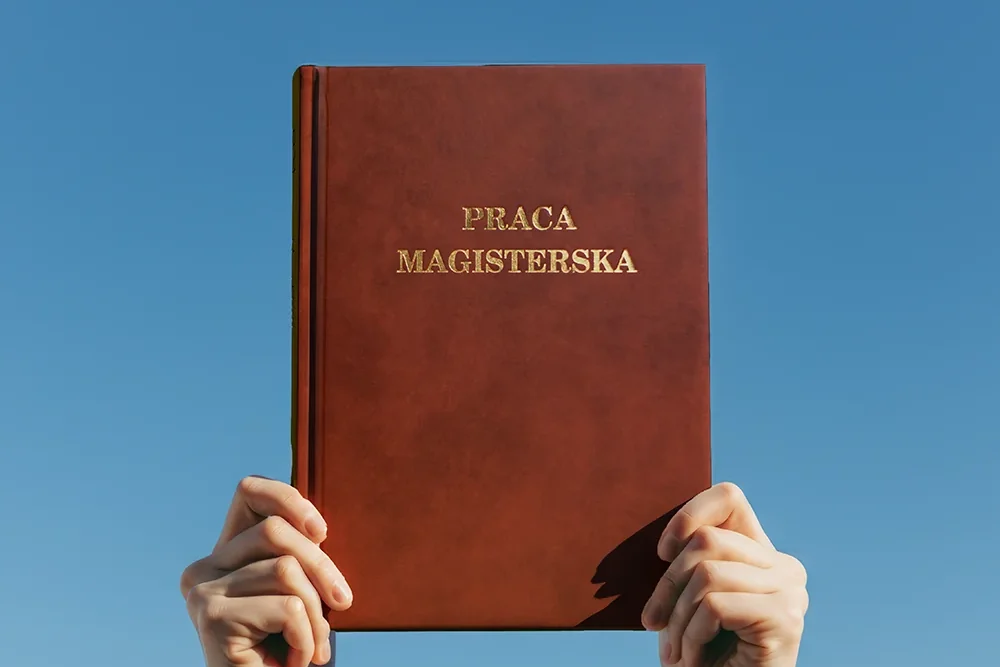 Złoty napis Praca magisterska na brązowej twardej oprawie