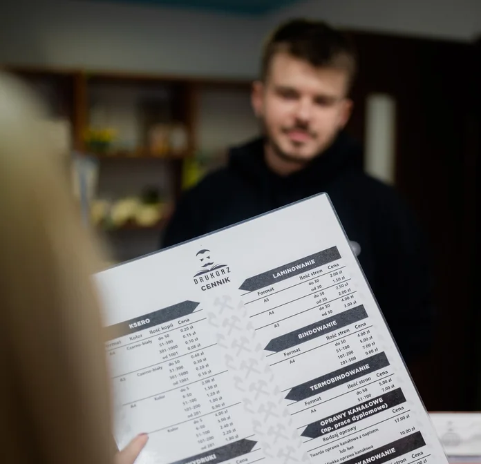 Pracownik Drukorz pokazuje klientce cennik w punkcie przy ul. Stawowej w Katowicach